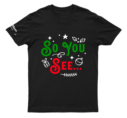 A black t-shirt with white mistletoe designs and "SO YOU" (in green) and "SEE..." in Red. Also features a printed label on the right sleeve: "Dhar Mann Studios"